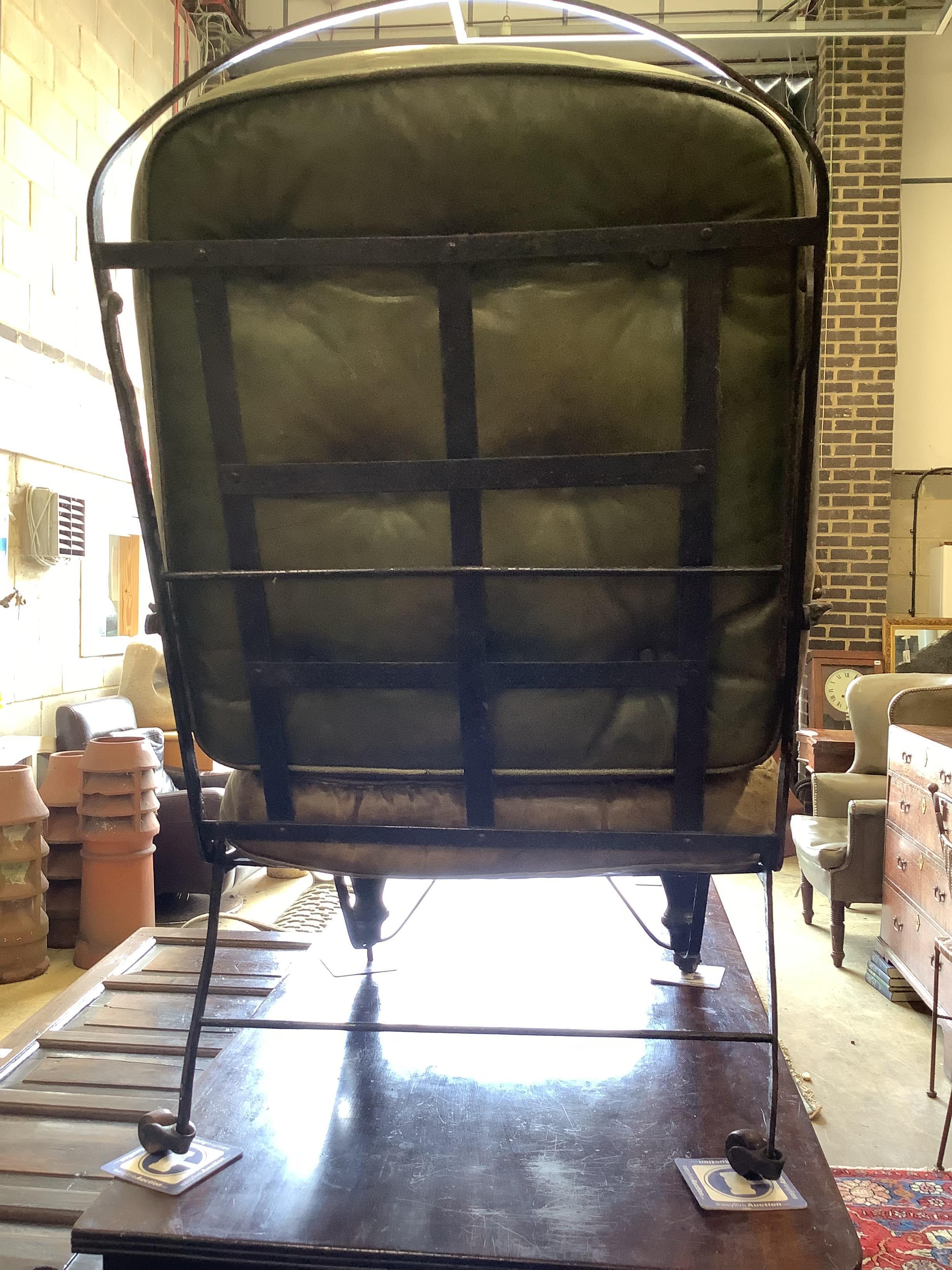 A 19th century wrought iron campaign chair with buttoned green leather seat and back